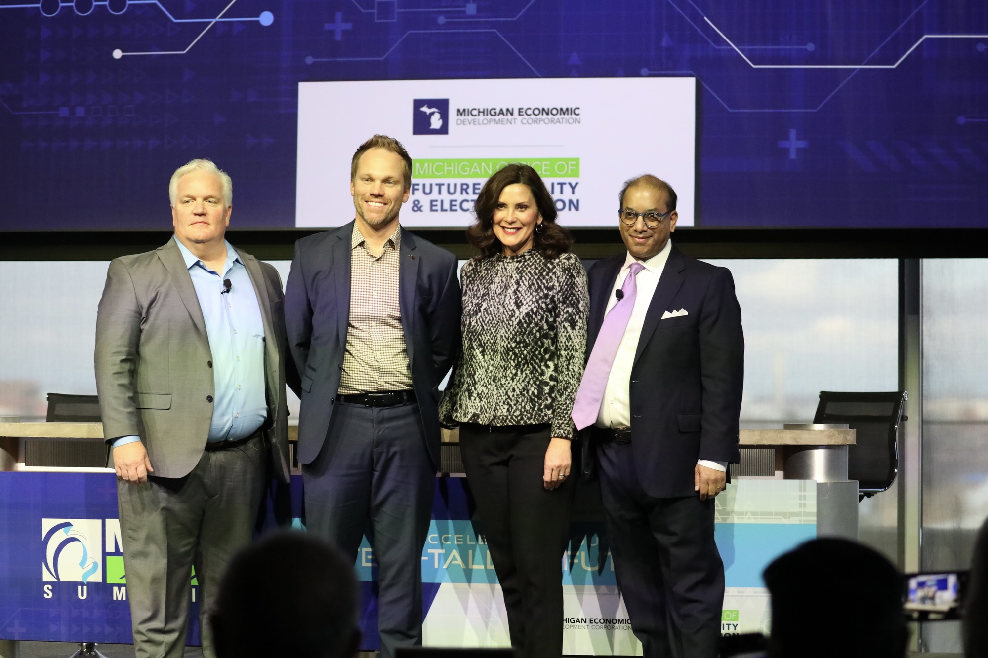 Gov. Whitmer stands alongside other speakers at the event