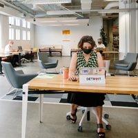 A woman sitting at a desk in the coworking space working on her laptop.