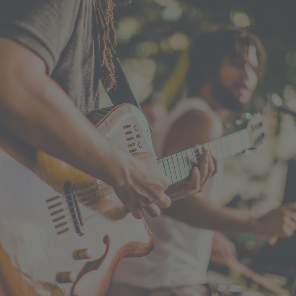 A performer plays a guitar in a band.