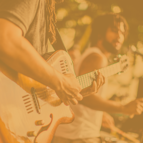 A performer plays a guitar in a band.