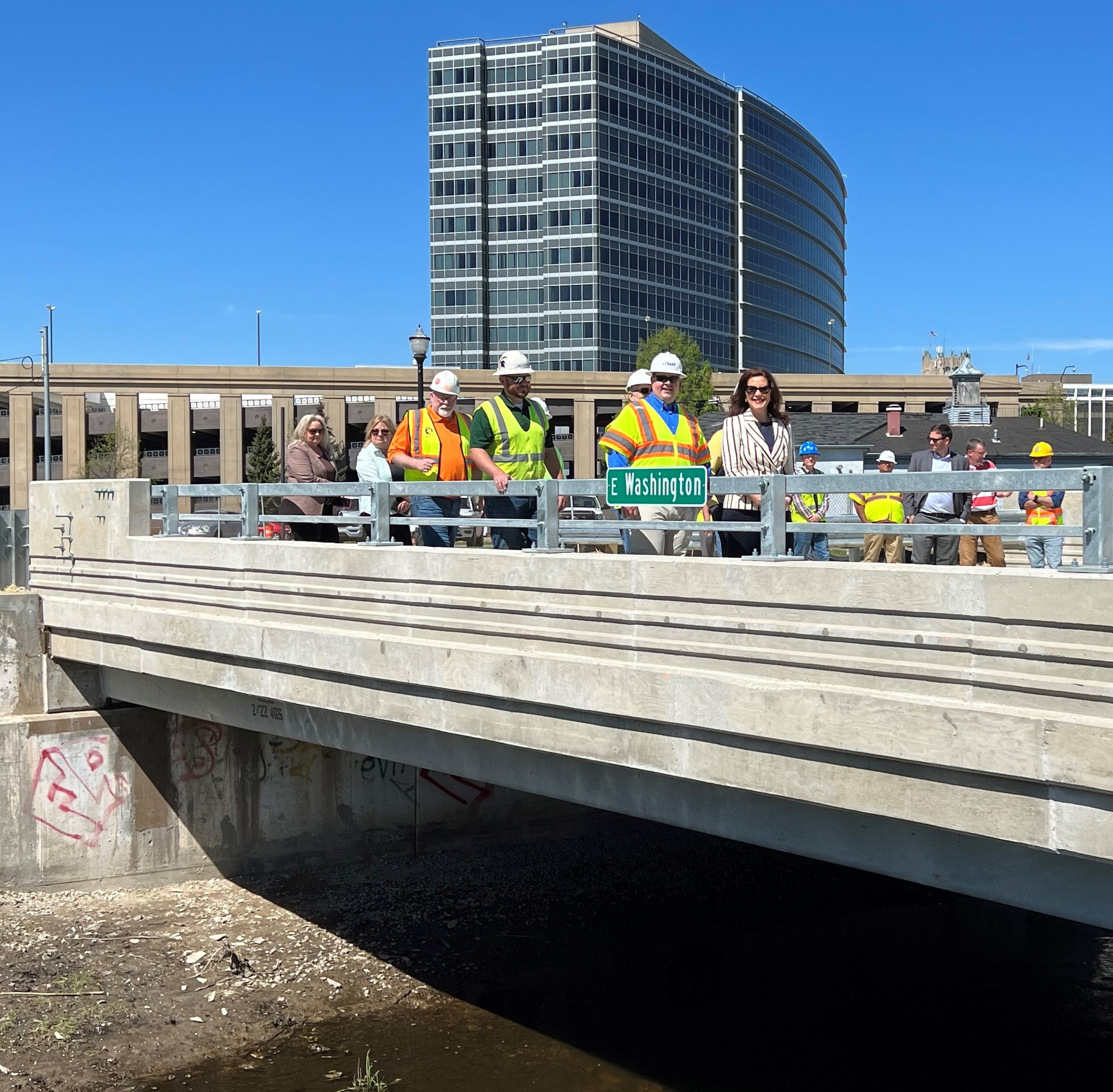 Gov. Whitmer walks with a group of people across the recently reopened bridge. 