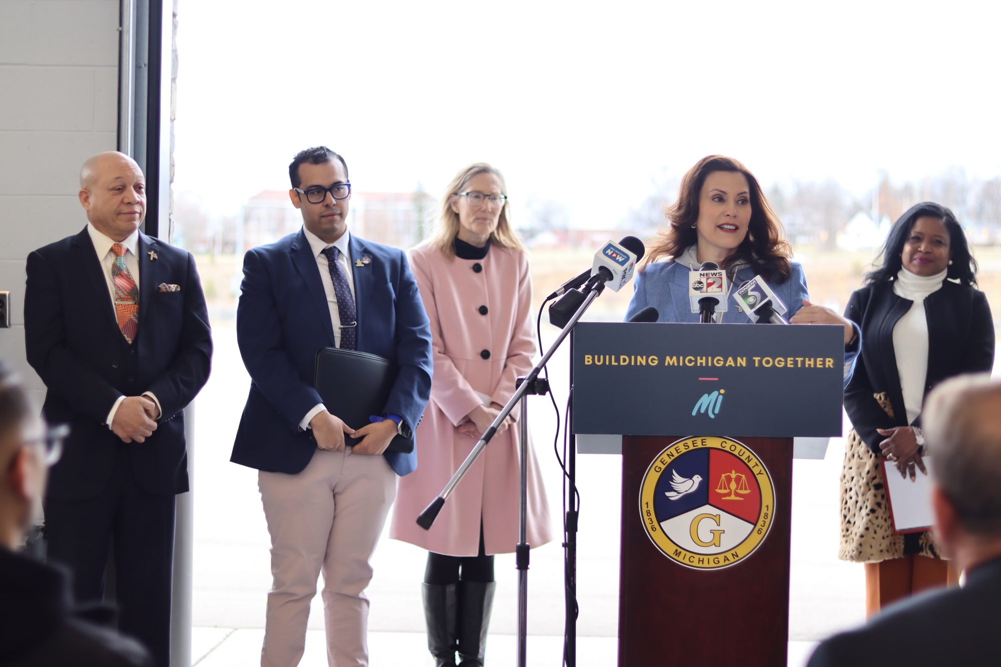 Gov. Whitmer speaking at podium at the Building Michigan Together event in Flint
